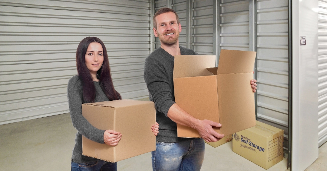 woman and man holding boxes in a self-storage unit