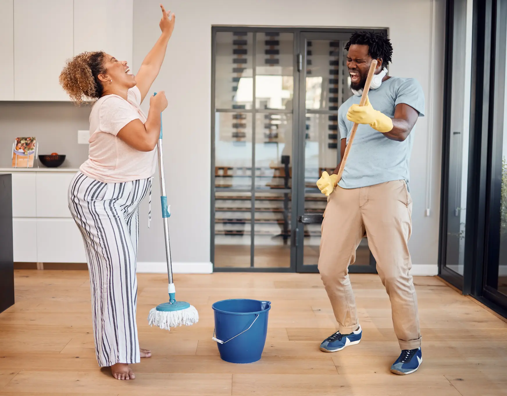Young couple rocking out with cleaning supplies Young couple rocking out with cleaning supplies