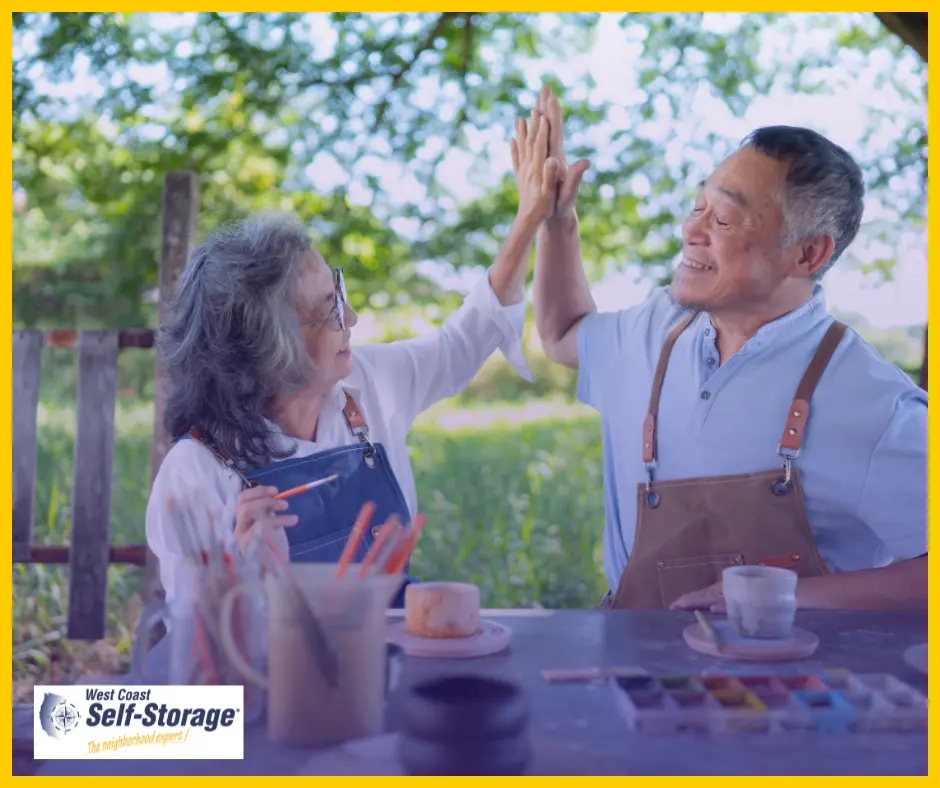 Retired couple paining and doing a high five Retired couple paining and doing a high five