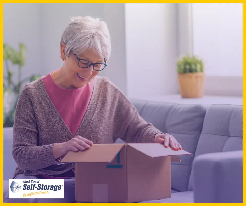 Retired woman looking into moving boxes Retired woman looking into moving boxes